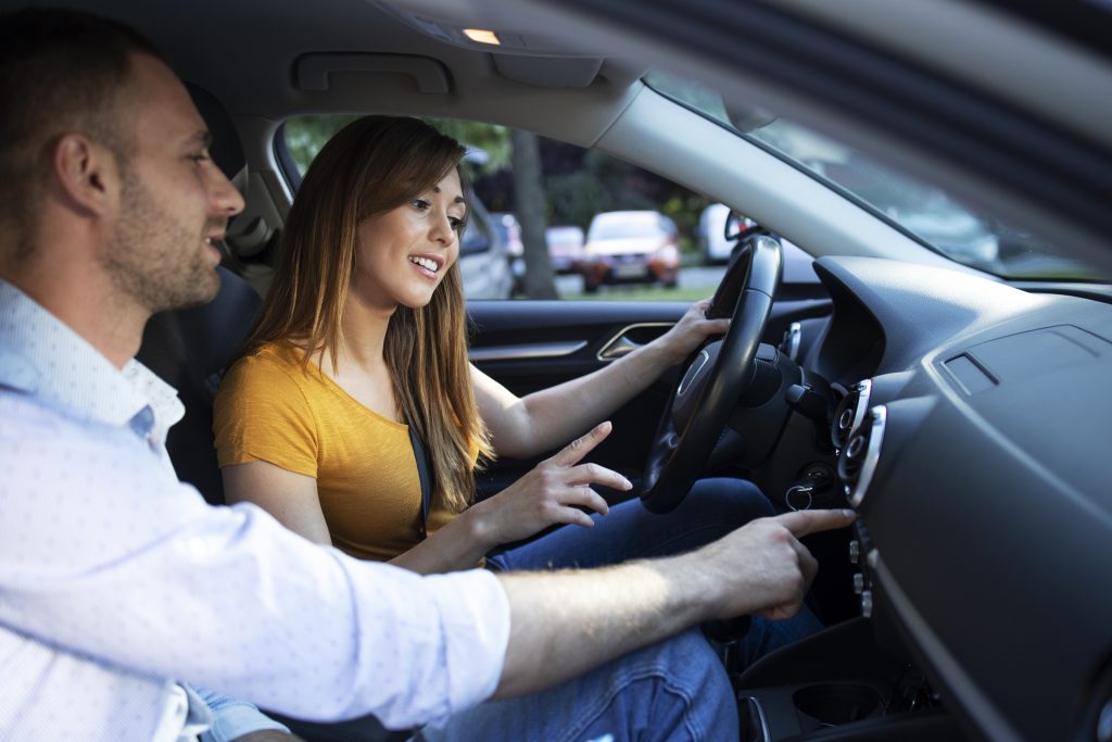Driving instructor showing vehicle dashboard
